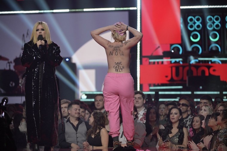 Avril Lavigne’s award show appearance interrupted by topless protestor
