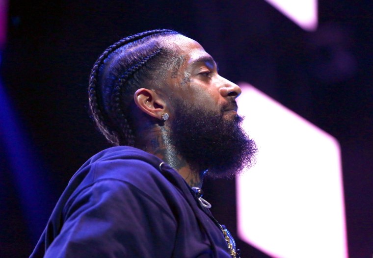 The man Nipsey Hussle was buying clothes for during fatal attack has been arrested for associating with the rapper