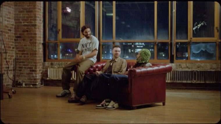 Wiki, Earl Sweatshirt, and Navy Blue post up on a couch in “All I Need” video